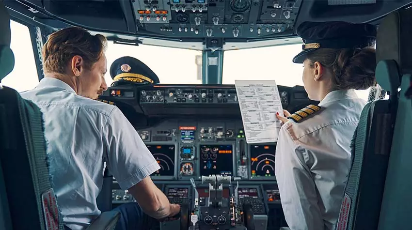 Pilot und Pilotin sitzen im Cockpit.  © Adobe Stock, Viacheslav Yakobchuk