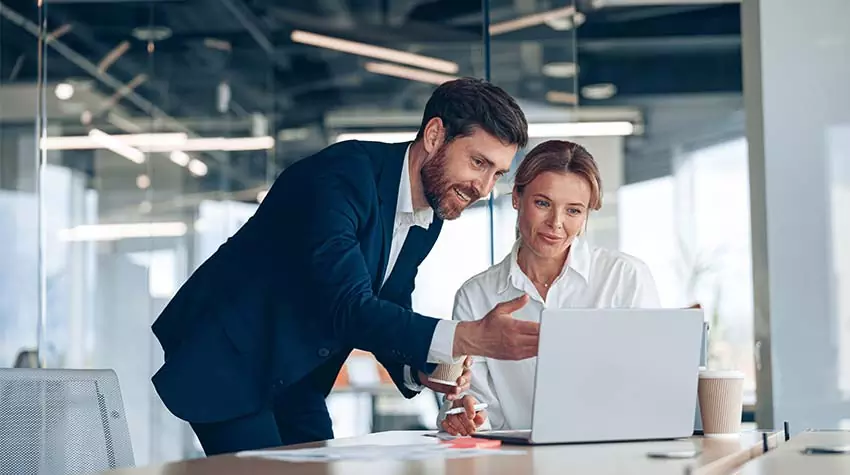 Mangerin und Manager in weißen Hemden schauen sich Präsentation auf dem Laptop im Büro an. © Adobe Stock, Yaroslav Astakhov