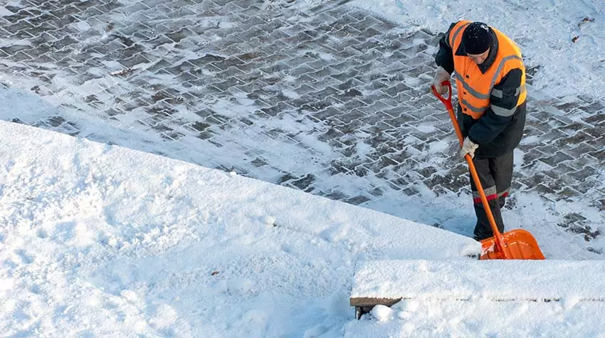 Ein Mann trägt bei der Durchführung des Winterdienstes warme und reflektierende Kleidung. © Adobe Stock, Pokoman